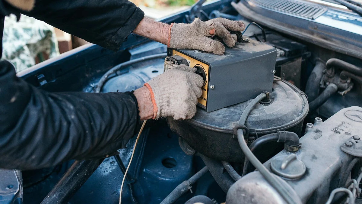 Mechanic measuring the voltage of an older car battery