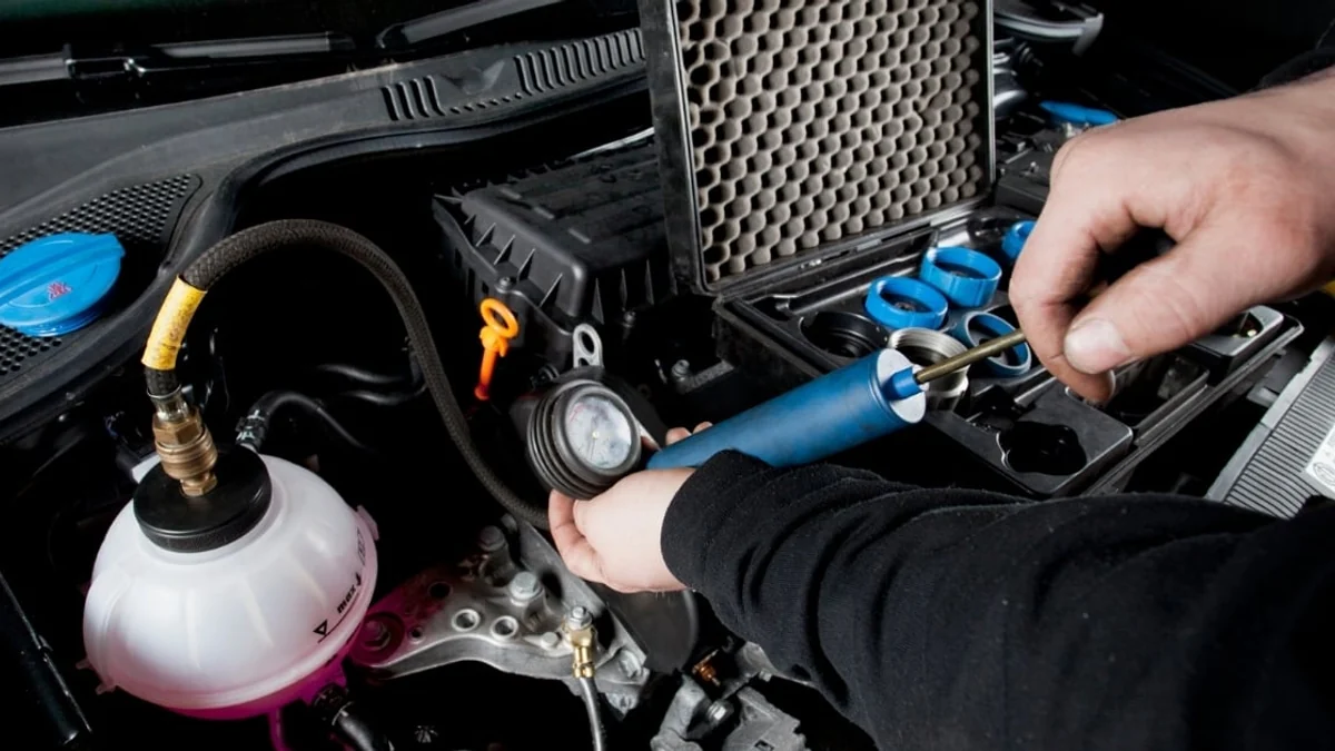Technician pressure-testing a vehicle cooling system for leaks