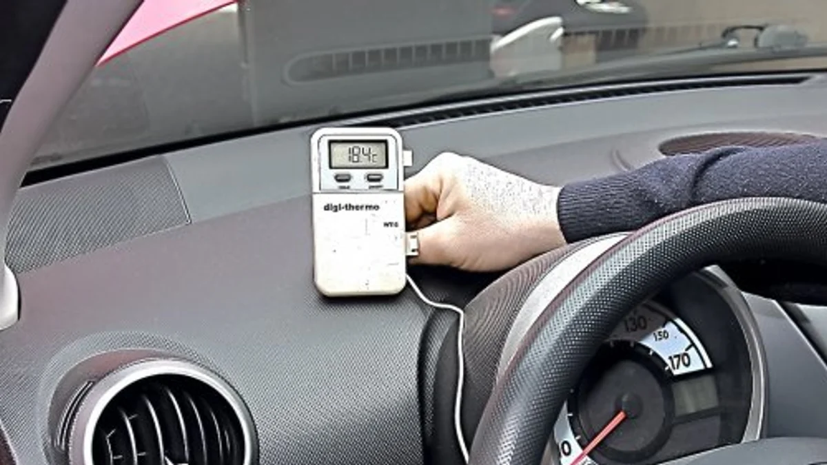 Digital thermometer measuring air temperature from a car dashboard vent