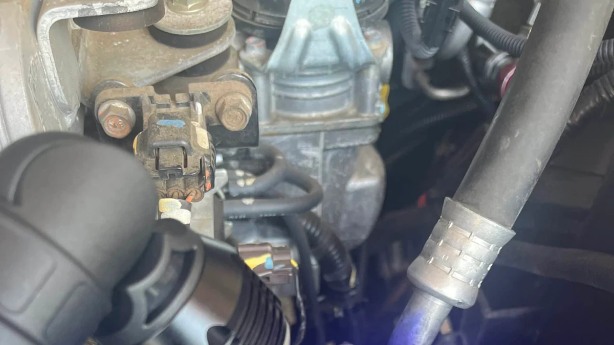Ultraviolet inspection revealing dye around a vehicle air-conditioning leak